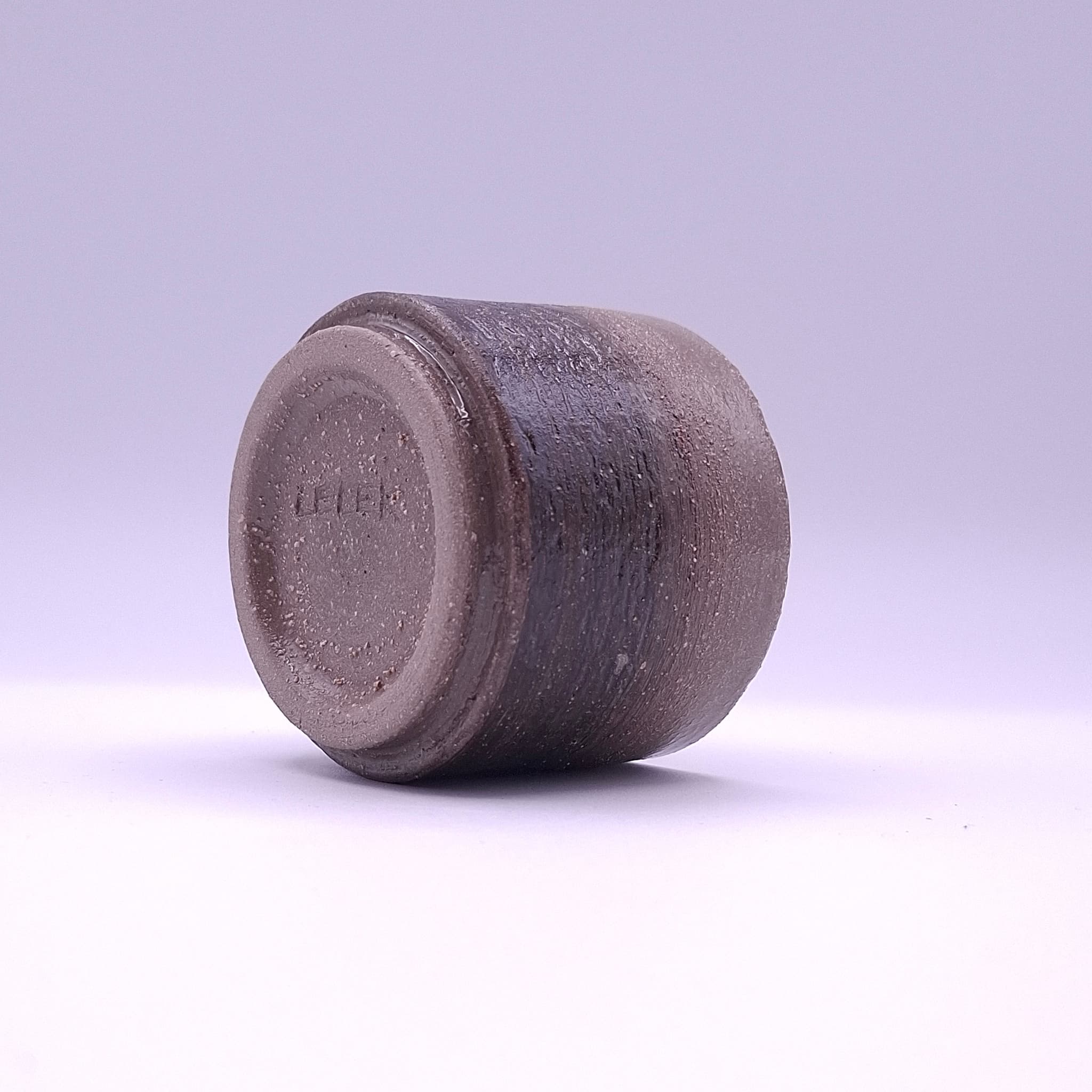 A handbuilt anthracite stoneware cup with white grog and an iron oxide band, shaped by hand in Berlin. One of a kind.
